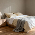 A serene, minimalist bedroom interior emphasizing health and restoration, featuring a clutter-free nightstand with closed drawers and soft, neutral linens under gentle morning light.