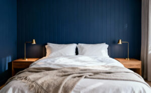 A deeply calming, modern bedroom featuring indigo blue paneled walls and crisp white bedding, emphasizing the psychological effect of low-luminance blue pigment.