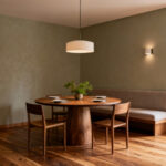 Serene dining room designed for intentionality, featuring a round wooden table, soft lighting, and natural elements, creating a purposeful dining sanctuary.