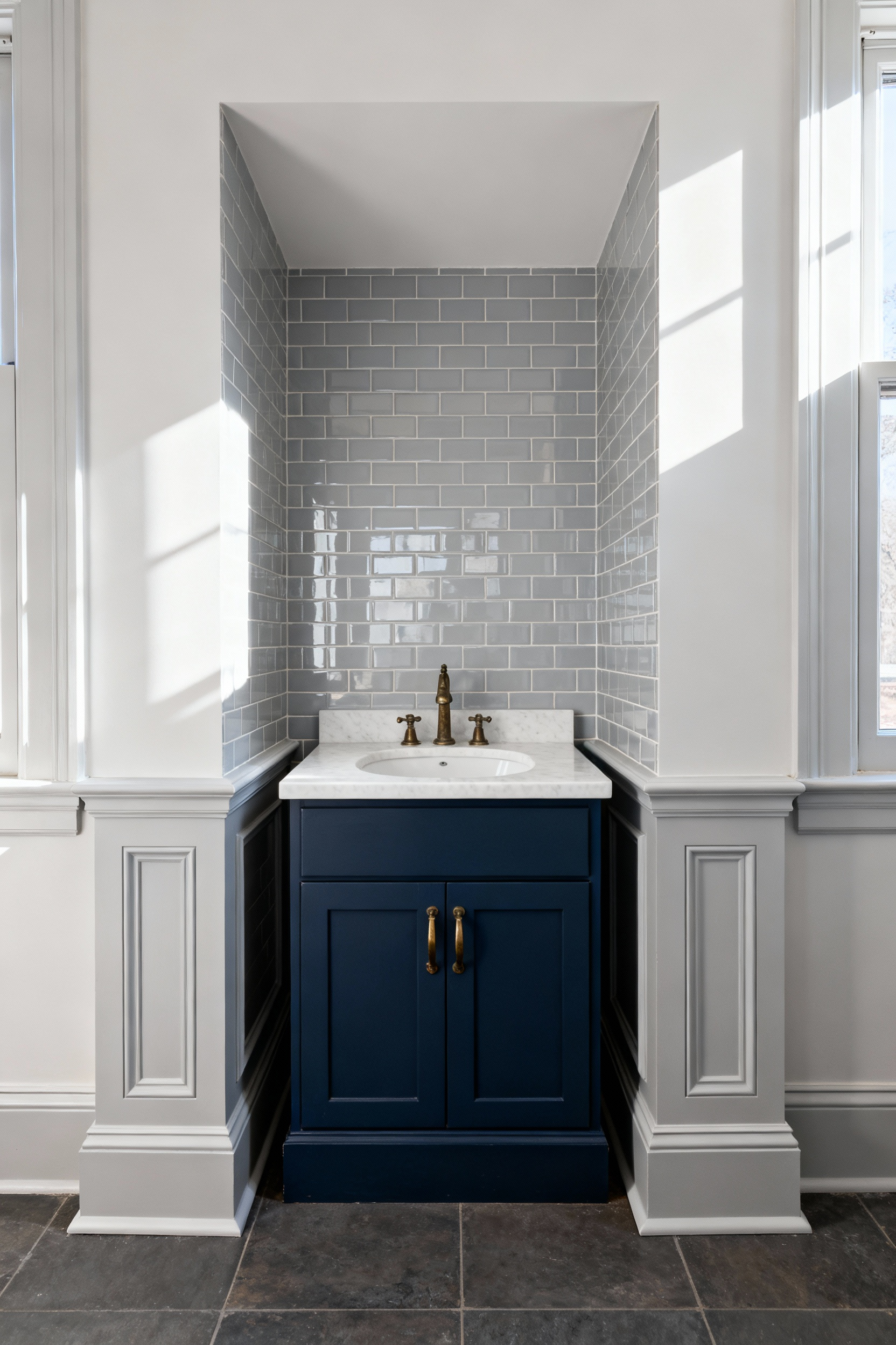 A standard navy blue vanity installed in a small bathroom alcove that is too wide for it, showing thick decorative filler strips on the left and right, illustrating wasted space due to rigid sizing.