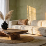 A contemporary living room design showcasing visual tension by placing a rough boucle sofa and a raw wood table next to smooth leather and polished brass elements, perfect for evolving living room styling ideas.