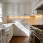 A full view of a traditional kitchen with white cabinetry and a four-inch natural stone backsplash made of Carrara marble.